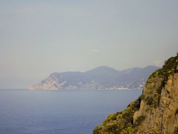 Scenic view of sea and mountains against clear sky