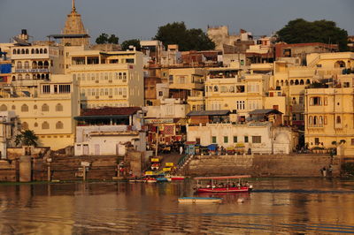 Boats moored on river by buildings in city