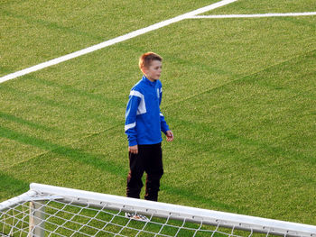 High angle view of boy standing on soccer field