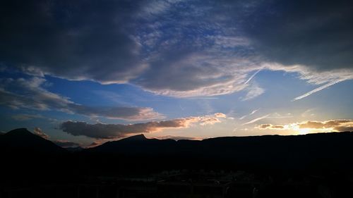 Scenic view of silhouette mountains against dramatic sky