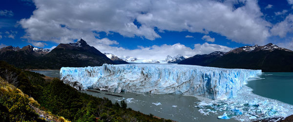 Scenic view of snowcapped mountains by sea against sky