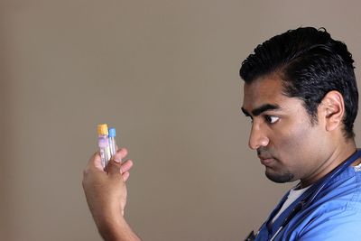 Side view of a man against gray background