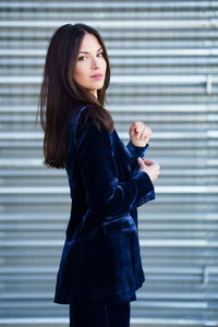 Portrait of beautiful woman standing against black background