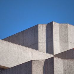 Low angle view of buildings against clear sky on sunny day