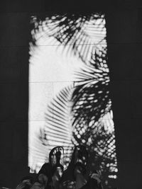 Side view of woman standing against wall