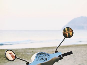 Motor scooter against sea at beach