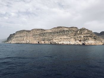 Rock formations by sea against sky