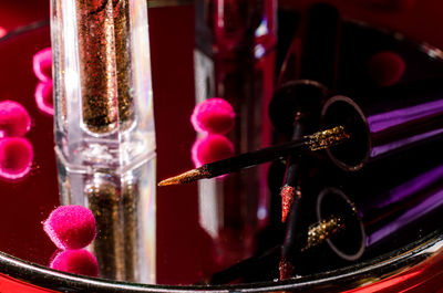 Close-up of pink flower in glass container on table