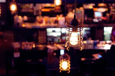 Close-up of illuminated light bulb in restaurant at night