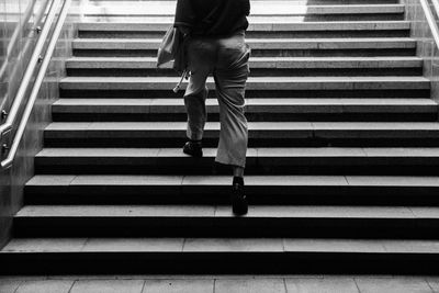 Low section of man walking on staircase