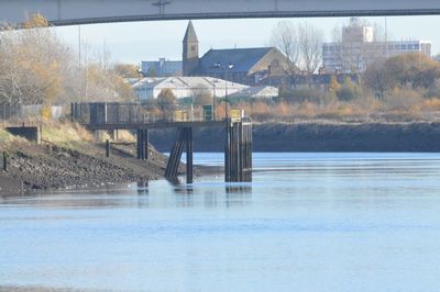 Reflection of built structure in water against sky