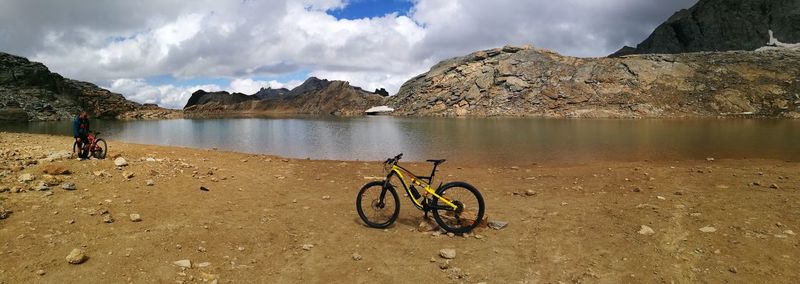 Bicycle by lake against sky