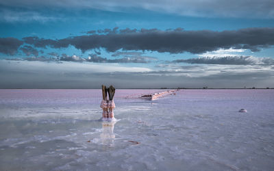 Woman standing at beach against sky