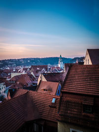 Houses in town against sky during sunset