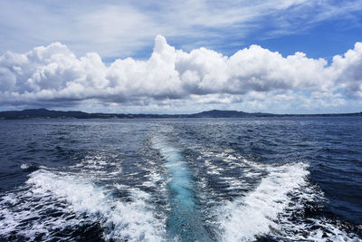 Scenic view of sea from a fast moving motor boat against sky