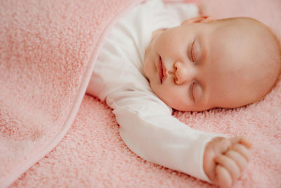 Portrait of cute baby sleeping on bed