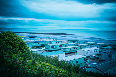 High angle view of townscape by sea against sky