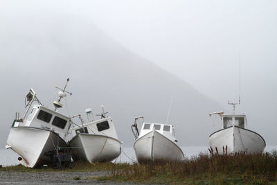 Ship moored on field against sky