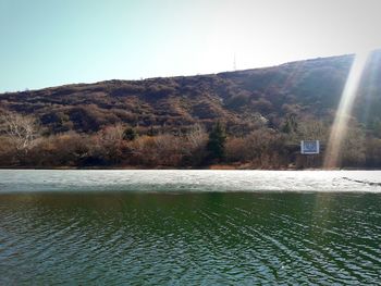 Scenic view of lake and mountains against clear sky