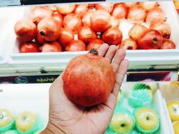 Close-up of hand holding apples in market