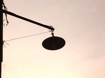 Low angle view of silhouette lamp against clear sky