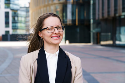 Business woman with folder in hand and glasses near business center