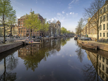 Canal amidst buildings against sky