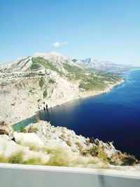 High angle view of sea and mountains against clear sky