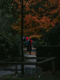 Man standing on bench in park during autumn