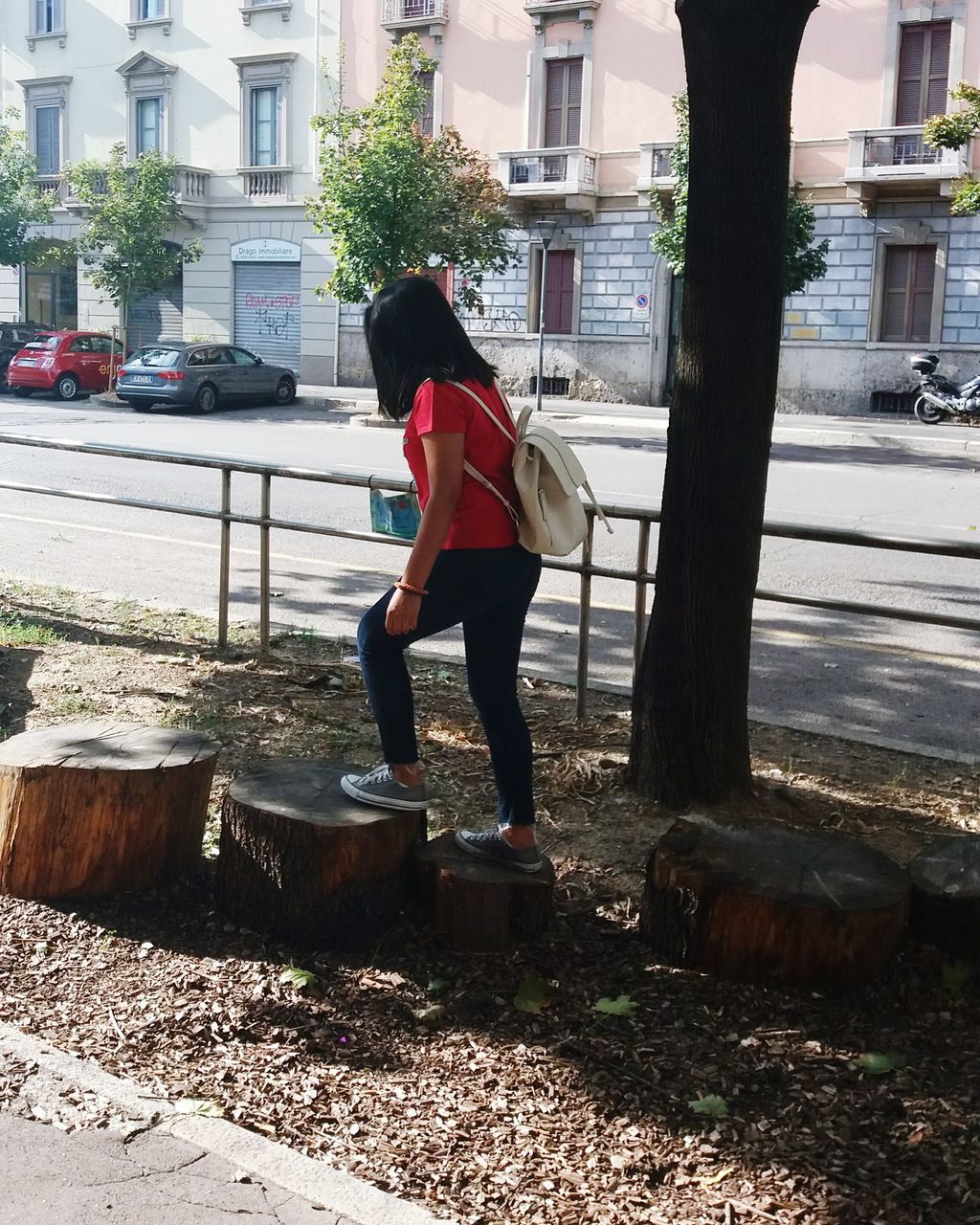 WOMAN STANDING ON TREE IN CITY