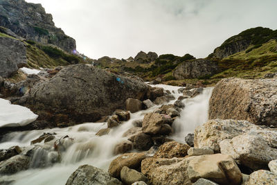 Scenic view of waterfall against sky