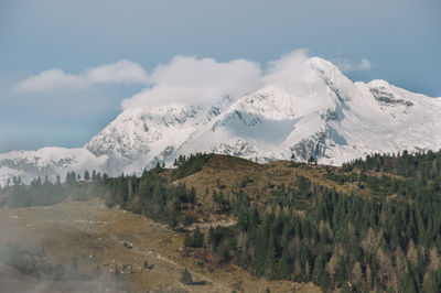 Foggy morning landscape with snowy mountains