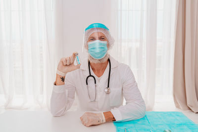 Portrait of doctor holding vaccine of covid-19