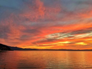 Fiery red and gold sunset reflection in the water.