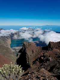 Panoramic view of volcanic landscape against blue sky