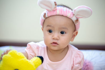 Cute baby girl wearing bunny ears headband at home