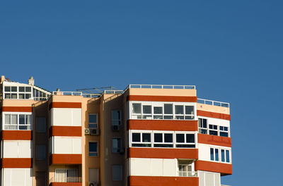 Low angle view of buildings against clear blue sky