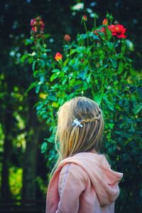 Side view of girl standing against plants in park