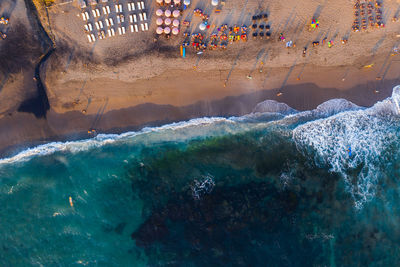 Aerial view of people enjoying on beach against sea