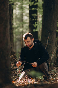 Young man looking away in forest