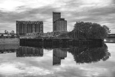 Reflection of buildings in lake against sky