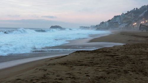 View of beach against cloudy sky