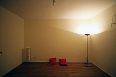 Empty room with cushions and illuminated lamp