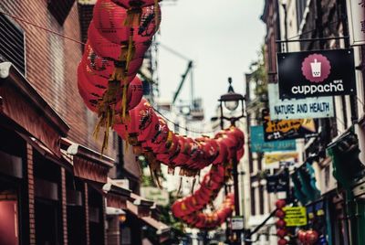 Red chinese lanterns hanging amidst city buildings