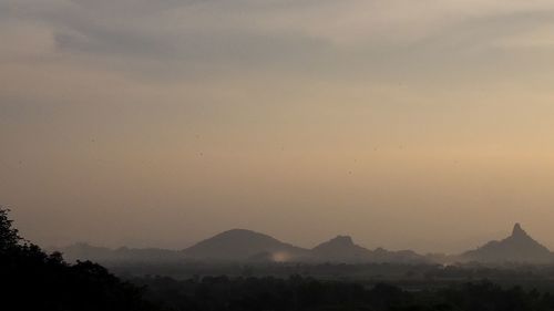 Scenic view of silhouette mountains against sky at sunset