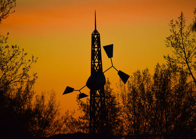 Silhouette of road sign against orange sky