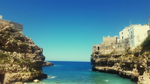 Panoramic view of sea and buildings against clear blue sky