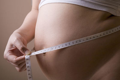 Close-up of pregnant woman measuring abdomen