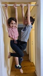 Full length of mother and daughter on floor at home