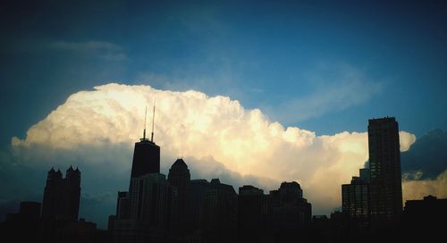 Silhouette of buildings against cloudy sky